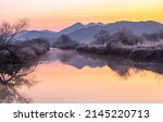 Sunrise view of Hwapocheon Wetland Ecological Park with ducks on calm water in winter near Gimhae-si, South Korea 
