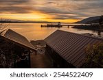 Sunrise view of the Lummi Island ferry dock during a during a dramatic and colorful sunrise. The view includes two small summer cabins that make this waterfront view even more interesting.