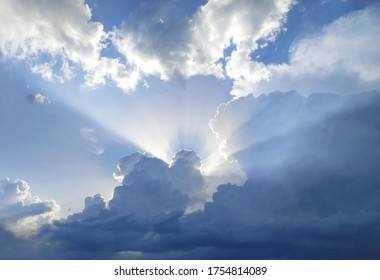 The sun's rays behind the cumulus clouds