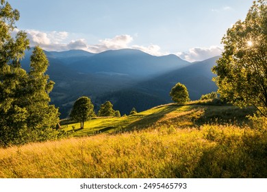 The sun's rays illuminate the green slopes in the mountainous area. Location place Carpathian mountains, Ukraine, Europe. Image of attractive scene, photo wallpapers. Discovery the beauty of earth. - Powered by Shutterstock