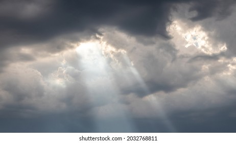 The sun's rays penetrate through the dark clouds during sunset, panorama - Powered by Shutterstock