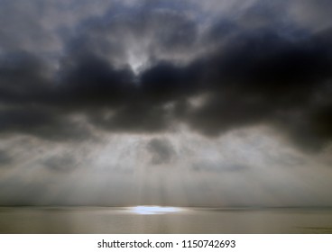the sun's rays Shine through the clouds on the sea surface