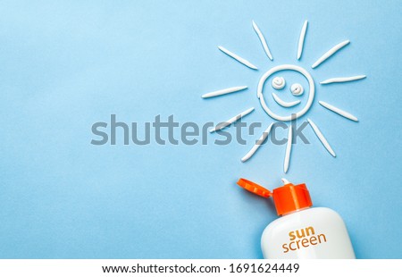 Sunscreen. Cream in the form of sun on blue background with white tube.