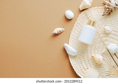 Sunscreen Cream Lotion Bottle And Seashells On Sandy Color Background. Flat Lay, Top View, Overhead.