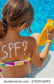 Sunscreen on the back of the child. Selective focus. Kid.