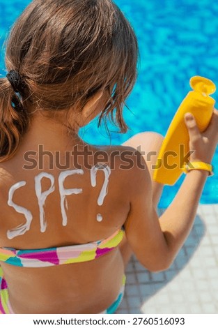 Sunscreen on the back of the child. Selective focus. Kid.