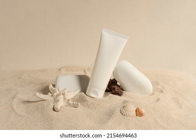 Sunscreen in white plastic tube. Studio photo shoot with sand, shells and white stones. Sand-colored environment. Sunscreen with UVA and UVB protection. Summer atmosphere. Landscape format. - Shutterstock ID 2154694463