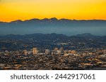 Sunset above downtown Glendale and San Gabriel Mountains in background viewed from Griffith Park near Los Angeles, California.