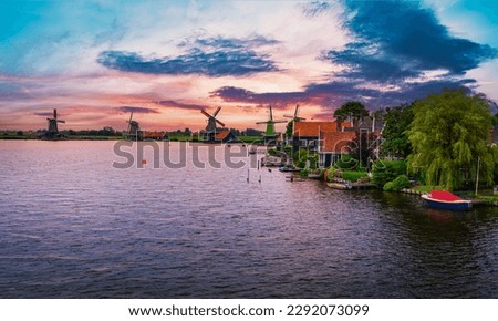 Sunset above historic farm houses and windmills in the holland village of Zaanse Schans near Amsterdam in the Netherlands.