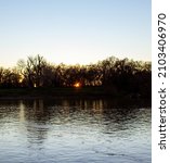 SUNSET across river, behind tree canopy