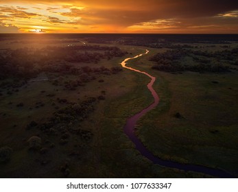 Sunset, aerial, atmospheric view on curving river Khwai, Moremi forest, Botswana. Typical ecosystem, part of Okavango delta, aerial photography. Vast wilderness without people, animal paradise.Africa.