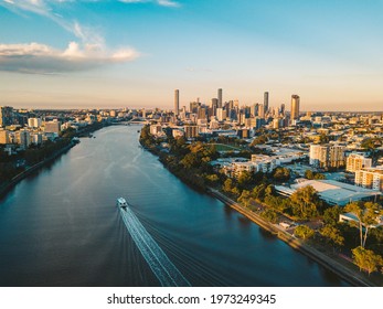Sunset aerial shot of Brisbane as a City Cat heads towards the city on the Brisbane River
