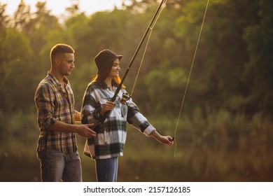 Sunset aesthetics. Young beautiful couple spending time in nature, near river and fishing. Nice summer weekend. Fresh air breathing, having fun. Concept of leisure time, relationship, fun, ad