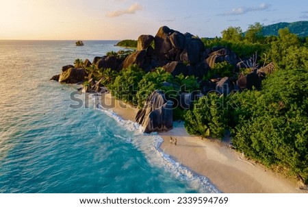 sunset at Anse Source d'Argent, La Digue Seychelles, a young couple of men and women on a tropical beach during a luxury vacation in Seychelles. Tropical beach Anse Source d'Argent, La Digue 