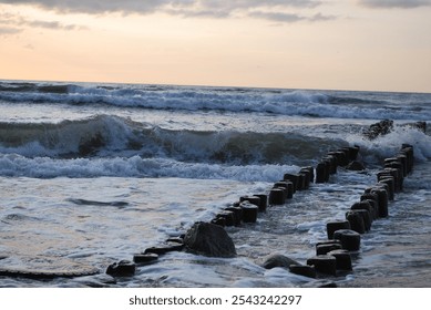 sunset, Baltic Sea, Curonian Spit, breakwaters, driftwood, waves, sunset sky, seascape, sea, coast, sun rays, evening light, clouds at sunset, romance of the sea, nature, tranquility, reflection of th - Powered by Shutterstock