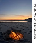 sunset beach bonfire: warm flames of a beach fire light up the evening as the sun sets over the ocean. enjoying the cozy atmosphere and the soothing sounds of waves.