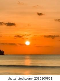 Sunset at the beach. Calm waves and also a bit cloudy sky complete the beauty of the sea scape.