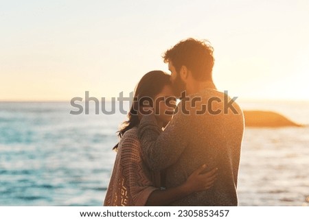 Sunset, beach and couple kiss forehead for relax, bonding and quality time on romantic date. Nature, travel and man and woman embrace for anniversary or honeymoon on holiday, weekend and vacation