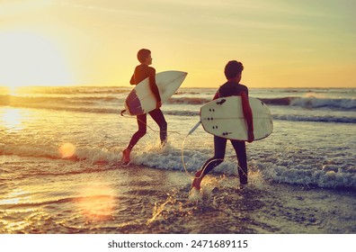 Sunset, beach and kids with board to surf on adventure in summer vacation and holiday. Children, learning and swimming in sea on island with waves to exercise in tropical nature or relax at ocean - Powered by Shutterstock