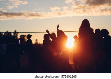 Sunset beach party dancers silhouettes  near volleyball court