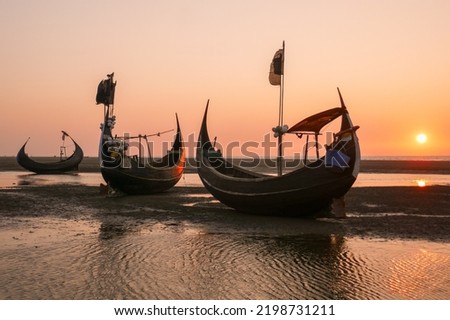 Sunset with beautiful traditional wooden fishing boats known as moon boats on beach near Cox's Bazar in southern Bangladesh	
