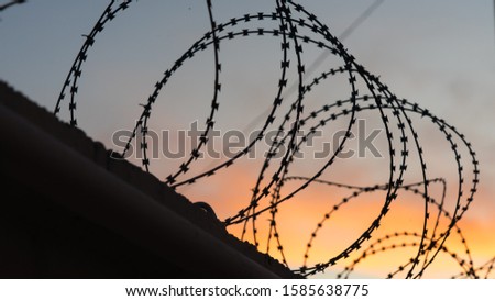 Similar – Fence with a barbed