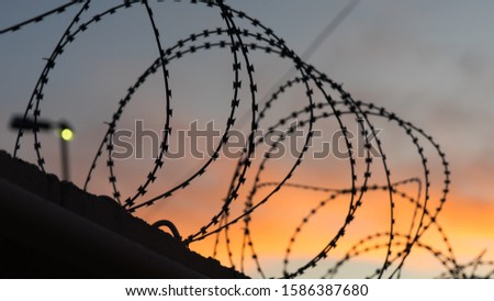 Similar – Fence with a barbed