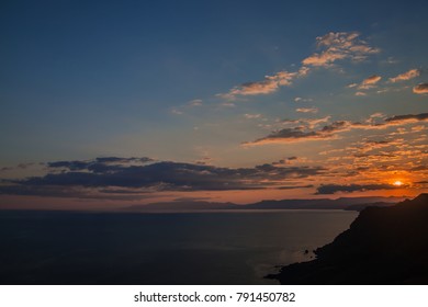 
sunset behind the clouds on the background of the sea