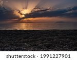 sunset behind the clouds on the beach