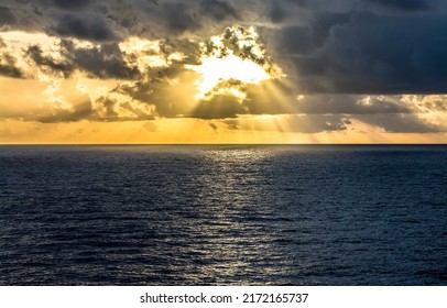 Sunset behind clouds over the sea horizon. Beautiful sunset over sea horizon. Sea horizon at sunset. Sea horizon sunset landscape