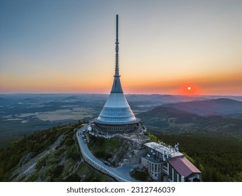 Sunset behind Jested Mountain with unique building on the summit. Liberec, Czech Republic. Aerial view from drone.