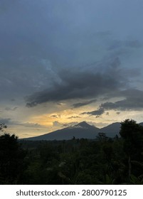 Sunset Behind Mountain Silhouette with Dramatic Clouds Over Tropical Forest