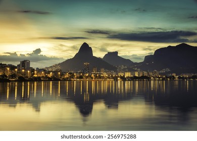 Sunset behind mountains in Rio de Janeiro with water reflection, Brazil