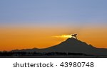 Sunset behind Mt. Redoubt Volcano in Alaska letting off steam and ash cloud.
