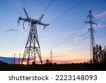 Sunset behind powerlines and pylons. Energy crisis and blackouts concept