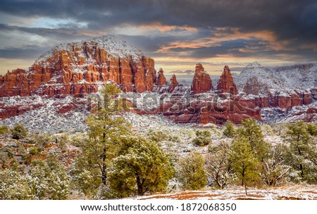 Sunset behing the snow covered red rocks near Sedona, Arizona afer a light snow fall.