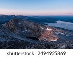 Sunset and blue hour midnight sun view from Tortenviktind, Helgeland, Norway. Arctic night of hiking in Norwegian fjell. Small alpine lakes and pieces of snow in summer hiking, Nordnorge. 