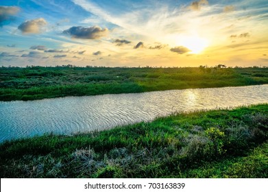 sunset and boats on the shore of the bayou in the southern marshes