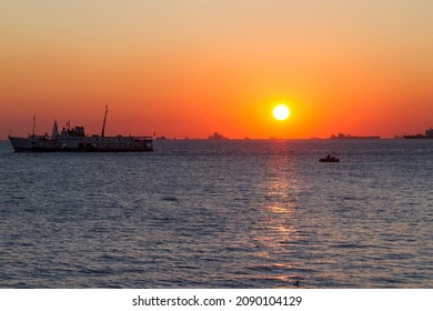 Sunset in Bosphorus water in Moda, asian Side of Istanbul, Turkey. Spectacular orange sunset and sea with boats. Boats in sea and scenic sunset in Turkey.  - Shutterstock ID 2090104129