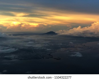 Sunset breaks up in the  clouds with the peak of a mountain in view