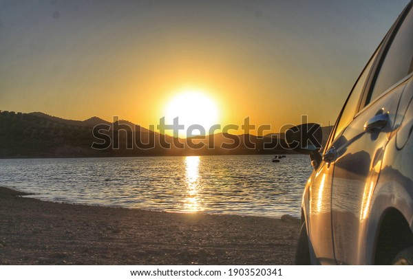 Sunset with the car on the\
beach