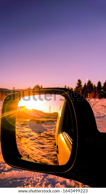 sunset in the car rearview\
mirror