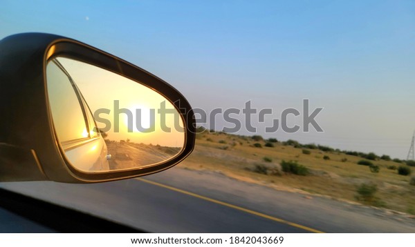 sunset in the car side mirror\
