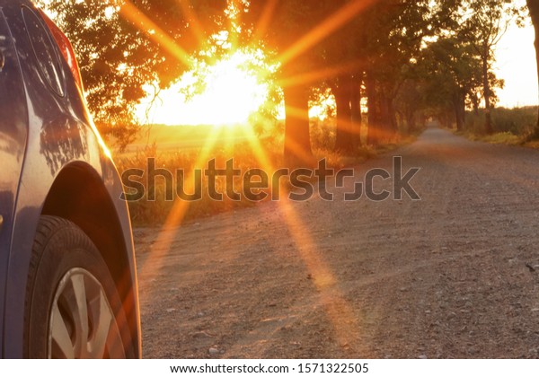 the sunset and the car, the sun's rays blue cars on
the road