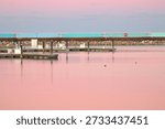 Sunset causing pink sky and water in the deserted marina during winter in Port Washington Wisconsin