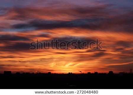 sunset in city with idustrial skyline and clouds, fire sky.