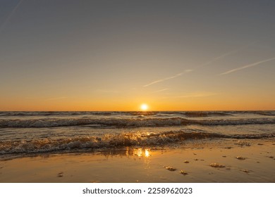 Sunset in a cloudless sky on the coast of the Gulf of Finland in Ust-Narva. The sky is clear, the waves gently roll on the sand. Estonia, Narva-Jyesuu. Natural background. Space for text. - Shutterstock ID 2258962023