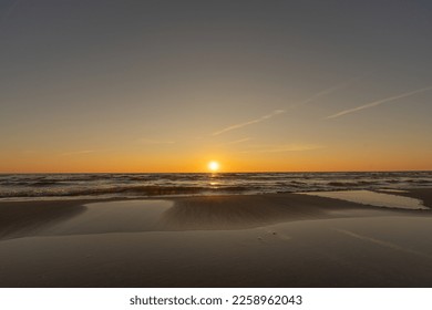 Sunset in a cloudless sky on the coast of the Gulf of Finland in Ust-Narva. The sky is clear, the waves gently roll on the sand. Estonia, Narva-Jyesuu. Natural background. Space for text. - Shutterstock ID 2258962043