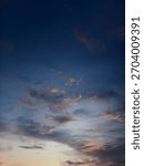 ​Dramatic sunset clouds fill a deep twilight sky, highlighted by streaks of orange and pink light near the horizon.The dark,intense blue dominates the upper frame,creating a striking moody atmosphere.
