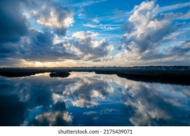 Sunset and clouds and sky reflected in Murrel's Inlet marsh near Garden City Beach, South Carolina coast